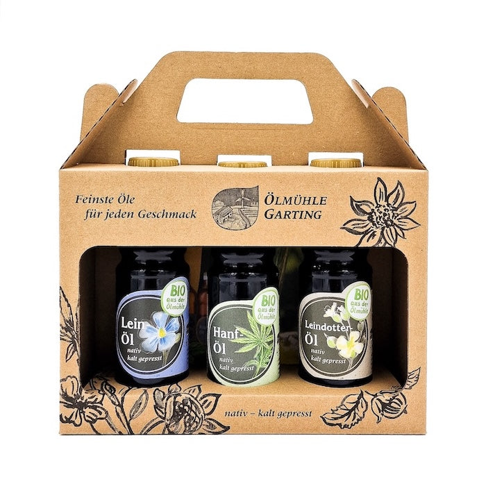 Geschenkset Bio Gesundheit kaltgepresst nativ mit 100 ml Flasche Bio Leinöl, 100 ml Flasche Bio Hanföl und 100 ml Bio Leindotteröl in einer Papiertasche auf weißem Hintergrund