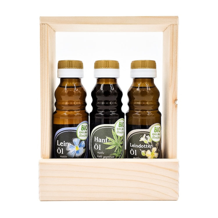 Geschenkset Bio Gesundheit kaltgepresst nativ mit 100 ml Flasche Bio Leinöl, 100 ml Flasche Bio Hanföl und 100 ml Bio Leindotteröl im Holztragerl auf weißem Hintergrund