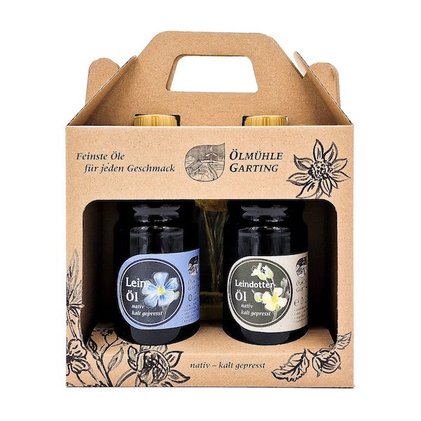 Geschenkset die Leinigen kaltgepresst nativ mit 250 ml Flasche Leinöl und 250 ml Flasche Leindotteröl in einer Papiertasche auf weißem Hintergrund