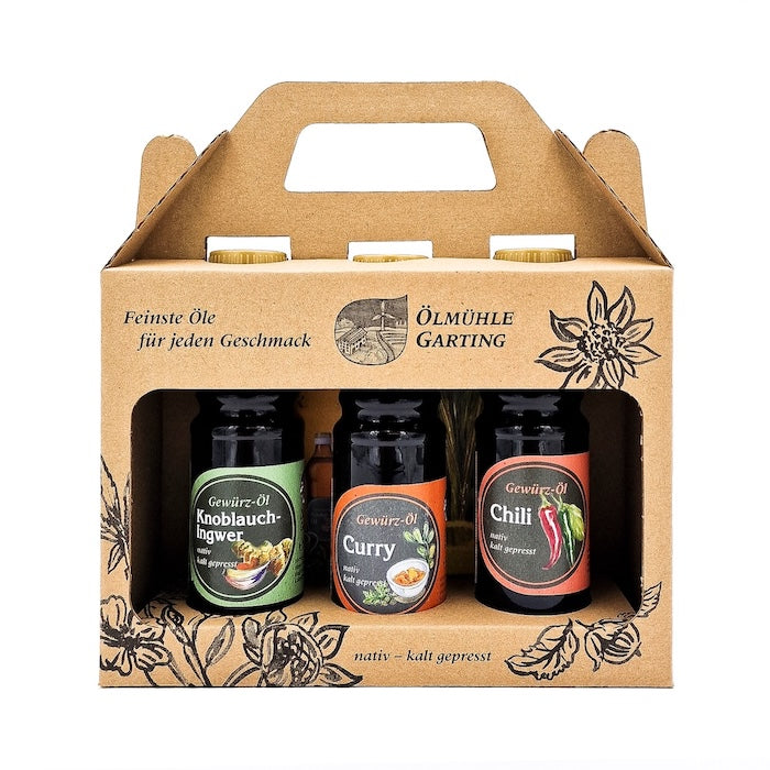 Geschenkset Würzlinge kaltgepresst nativ mit 100ml Flasche Knoblauch-Ingwer Gewürzöl, 100 ml Flasche Curry Gewürzöl und 100 ml Chili Gewürzöl in einer Papiertasche auf weißem Hintergrund