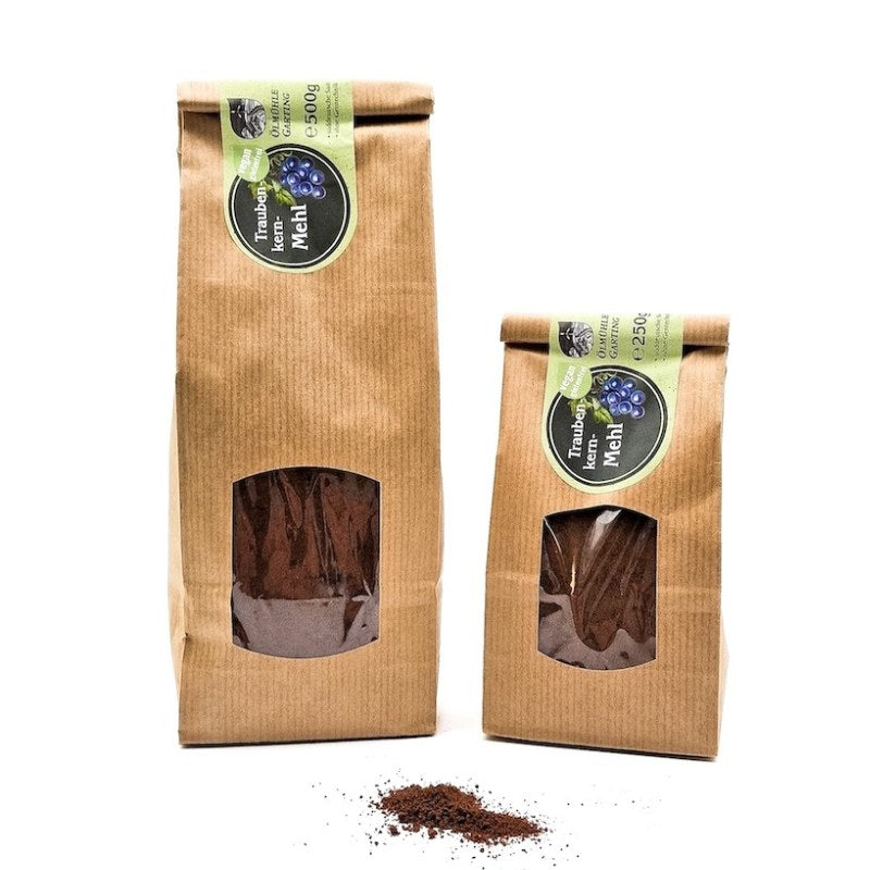 Traubenkernmehl Set, 250g und 500g Tüte der Ölmühle Garting, vegan und glutenfrei mit grünem Etikett auf weißem Hintergrund, im Vordergrund Traubenkernmehl