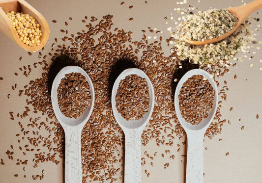Leinsamen, Hanfsamen und Senfsamen auf beigem Hintergrund 