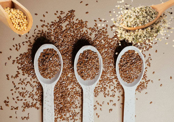 Leinsamen, Hanfsamen und Senfsamen auf beigem Hintergrund 