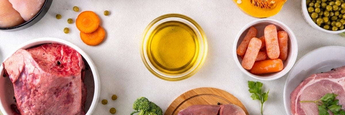 Verschiedene Futtermittel für Tiere mit Fleisch, Innereien, Gemüse, Haferflocken und Pflanzenöl