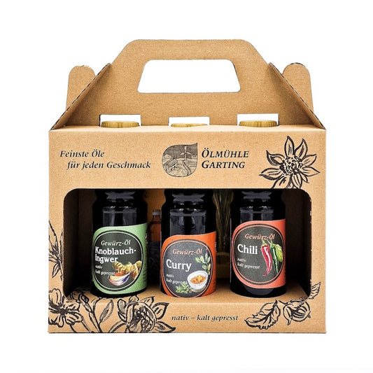 Geschenkset Würzlinge kaltgepresst nativ mit 100ml Flasche Knoblauch-Ingwer Gewürzöl, 100 ml Flasche Curry Gewürzöl und 100 ml Chili Gewürzöl in einer Papiertasche auf weißem Hintergrund