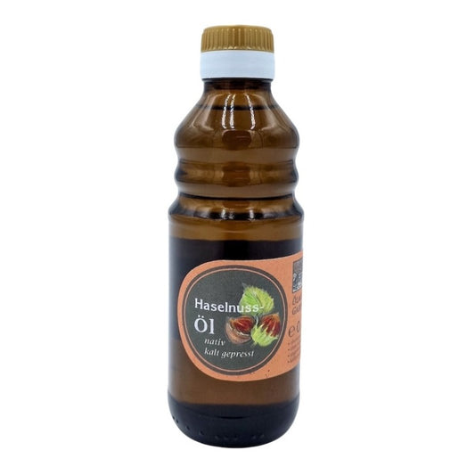 Haselnuss Öl nativ kaltgepresst, 250 ml in brauner Glasflasche der Ölmühle Garting mit braunem Etikett auf weißem Hintergrund