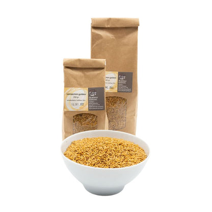 Leinsamen gold naturbelassen, 500g und 250g Tüte golden der Ölmühle Garting auf weißem Hintergrund, im Vordergrund goldene Leinsamen