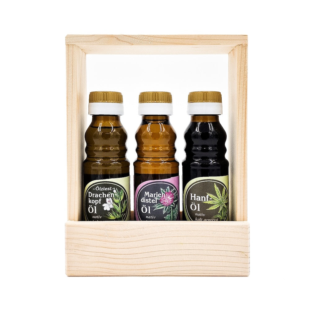 Geschenkeset Vitalset nativ kaltgepresste Öle, 100 ml Flaschen der Ölmühle Garting mit Drachenkopföl, Mariendistelöl und Hanföl in Holztragerl auf weißem Hintergrund