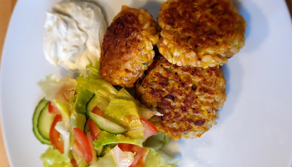 Bayrische Reispflanzerl mit Dip und Salat auf weißem Teller